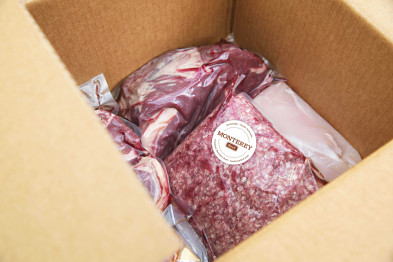 Cuts of Beef packaged up in plastic and sitting in a cardboard box.